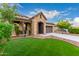 Charming single-Gathering home featuring a stone archway entrance, well-kept lawn, and a two-car garage at 21972 N 97Th Gln, Peoria, AZ 85383