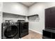 Modern laundry room with front-load washer/dryer, shelves, and a convenient storage nook at 21972 N 97Th Gln, Peoria, AZ 85383