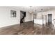 Open-concept living room with wood floors, kitchen island, and modern lighting fixtures at 21972 N 97Th Gln, Peoria, AZ 85383