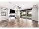 Large living room featuring tile floors, a fireplace, a fan, and sliding doors to the backyard at 21972 N 97Th Gln, Peoria, AZ 85383