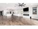 Spacious living area with a fireplace, a fan, and views into the kitchen with a large island at 21972 N 97Th Gln, Peoria, AZ 85383