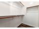 Bright walk-in closet with wooden rods for hanging clothes and wood-look flooring at 21972 N 97Th Gln, Peoria, AZ 85383