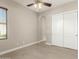 Clean bedroom with ceiling fan, window, and closet featuring modern sliding doors at 22290 E Escalante Rd, Queen Creek, AZ 85142