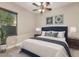 Charming bedroom with a cozy bed, neutral colors, ceiling fan and bright natural light from the window at 22290 E Escalante Rd, Queen Creek, AZ 85142