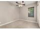 Bright, empty bedroom with a ceiling fan and window with window coverings at 22290 E Escalante Rd, Queen Creek, AZ 85142
