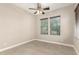 Neutral bedroom featuring a ceiling fan and two windows for natural light at 22290 E Escalante Rd, Queen Creek, AZ 85142