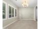 Airy dining area featuring three windows, modern chandelier, and a seamless transition to other areas at 22290 E Escalante Rd, Queen Creek, AZ 85142