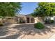 Paver driveway leads to a charming home with stone accents and lush, mature landscaping at 22290 E Escalante Rd, Queen Creek, AZ 85142