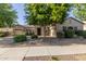 Charming single-story home with stone accents, lush landscaping, and a well-manicured front yard at 22290 E Escalante Rd, Queen Creek, AZ 85142