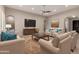 Open-concept living area with comfortable seating, accent pillows, ceiling fan, and seamless transition to other areas at 22290 E Escalante Rd, Queen Creek, AZ 85142