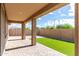 Covered back patio featuring brick pavers, synthetic grass, and a block wall for privacy at 23195 S 226Th Way, Queen Creek, AZ 85142