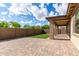 Spacious backyard with a covered patio, synthetic grass, brick pavers, and block fence at 23195 S 226Th Way, Queen Creek, AZ 85142