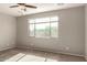 Sun-filled bedroom with neutral carpet, ceiling fan, and large window at 23195 S 226Th Way, Queen Creek, AZ 85142