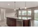 Kitchen island with stainless steel dishwasher and sink; tiled floors and light-filled windows at 23195 S 226Th Way, Queen Creek, AZ 85142