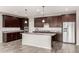 Spacious kitchen boasts dark cabinets, stainless steel appliances, a center island, and granite countertops at 23195 S 226Th Way, Queen Creek, AZ 85142