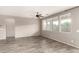 Open-concept living room boasts wood-look tile flooring, neutral paint, and a ceiling fan at 23195 S 226Th Way, Queen Creek, AZ 85142