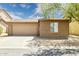 Tan single-story home features a two-car garage, desert landscaping, and a neutral color scheme at 2327 E Meadow Land Dr, San Tan Valley, AZ 85140