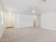Open-plan living room with neutral carpet, a ceiling fan, and natural light from two windows at 2327 E Meadow Land Dr, San Tan Valley, AZ 85140