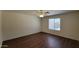 Neutral bedroom featuring a ceiling fan, window, and hard surface flooring at 23424 W Pima St, Buckeye, AZ 85326
