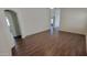 Living room with dark wood laminate floors, neutral paint, and arched doorway at 23424 W Pima St, Buckeye, AZ 85326