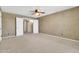 Bedroom with neutral walls and carpet, ceiling fan and double doors at 2346 E Jasmine St, Mesa, AZ 85213