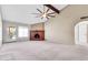 Spacious living room with a brick fireplace, vaulted ceiling, and a ceiling fan, great natural light at 2346 E Jasmine St, Mesa, AZ 85213