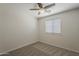 Cozy bedroom features neutral carpet, ceiling fan, and a window with blinds at 2408 W Saint Kateri Dr, Phoenix, AZ 85041