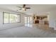 Open living room seamlessly connecting to the kitchen, and offering views of the pool through large windows and sliding doors at 2408 W Saint Kateri Dr, Phoenix, AZ 85041