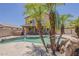 Backyard swimming pool area featuring stone details and palm trees at 2408 W Saint Kateri Dr, Phoenix, AZ 85041