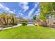 Inviting backyard features a sparkling blue pool, lush lawn, mature landscaping, and an umbrella-shaded seating area at 2920 W Michigan Ave, Phoenix, AZ 85053