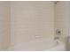 Bright bathroom featuring a bathtub with tile walls and a shower head at 2920 W Michigan Ave, Phoenix, AZ 85053