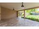 Covered patio area with tile floor, featuring landscaped yard with mature plants and trees at 2920 W Michigan Ave, Phoenix, AZ 85053