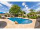 Backyard pool featuring a stone patio, lush landscaping, and mature trees, creating a private outdoor oasis at 2920 W Michigan Ave, Phoenix, AZ 85053