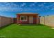Backyard with lush grass, enclosed by block fencing, and a versatile detached structure at 2936 E Willetta St, Phoenix, AZ 85008