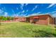 Backyard featuring well-maintained lawn, shaded patio, and a brick exterior, ideal for outdoor enjoyment at 2936 E Willetta St, Phoenix, AZ 85008