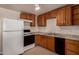 Well-lit kitchen with wood cabinets, white refrigerator, and black stove and dishwasher at 2936 E Willetta St, Phoenix, AZ 85008
