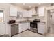 Bright kitchen with modern white cabinets, stainless steel appliances, and tile floors at 2936 E Willetta St, Phoenix, AZ 85008