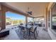 A covered patio offers an outdoor dining area, seating, and views of the pool and desert landscaping at 29749 N 130Th Dr, Peoria, AZ 85383