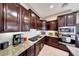 Modern kitchen with dark wood cabinets, granite countertops, stainless steel appliances, and ample storage at 29749 N 130Th Dr, Peoria, AZ 85383