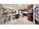 Spacious kitchen with a large island, dark wood cabinetry, bar seating, and an open layout at 29749 N 130Th Dr, Peoria, AZ 85383