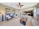 Spacious living room featuring a ceiling fan and open floor plan flowing into a kitchen at 29749 N 130Th Dr, Peoria, AZ 85383