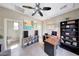 Spacious home office with an eclectic ceiling fan, a long desk, and storage cabinets at 29749 N 130Th Dr, Peoria, AZ 85383