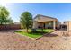Spacious backyard with manicured artificial grass, desert landscaping, a picnic table, and covered patio for outdoor living at 29809 W Columbus Ave, Buckeye, AZ 85396