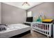 bedroom with white walls, a crib, a TV, and window bringing in natural light at 29809 W Columbus Ave, Buckeye, AZ 85396