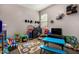 Inviting bedroom with plenty of toys, play table, a TV, and a bright window at 29809 W Columbus Ave, Buckeye, AZ 85396