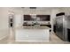Well-equipped kitchen featuring an island, granite counters, stainless steel appliances, and dark wood cabinets at 29809 W Columbus Ave, Buckeye, AZ 85396