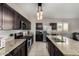 Modern kitchen with an island, granite countertops, stainless steel appliances and dark wood cabinets at 29809 W Columbus Ave, Buckeye, AZ 85396