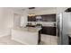 Eat-in kitchen boasts dark wood cabinetry, granite countertops, stainless appliances and a kitchen island at 29809 W Columbus Ave, Buckeye, AZ 85396