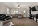 Bright living room featuring neutral walls, carpet flooring, generous windows and a modern ceiling fan at 29809 W Columbus Ave, Buckeye, AZ 85396