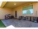 Covered patio with tile flooring, cages, chair, and backyard views at 29809 W Columbus Ave, Buckeye, AZ 85396